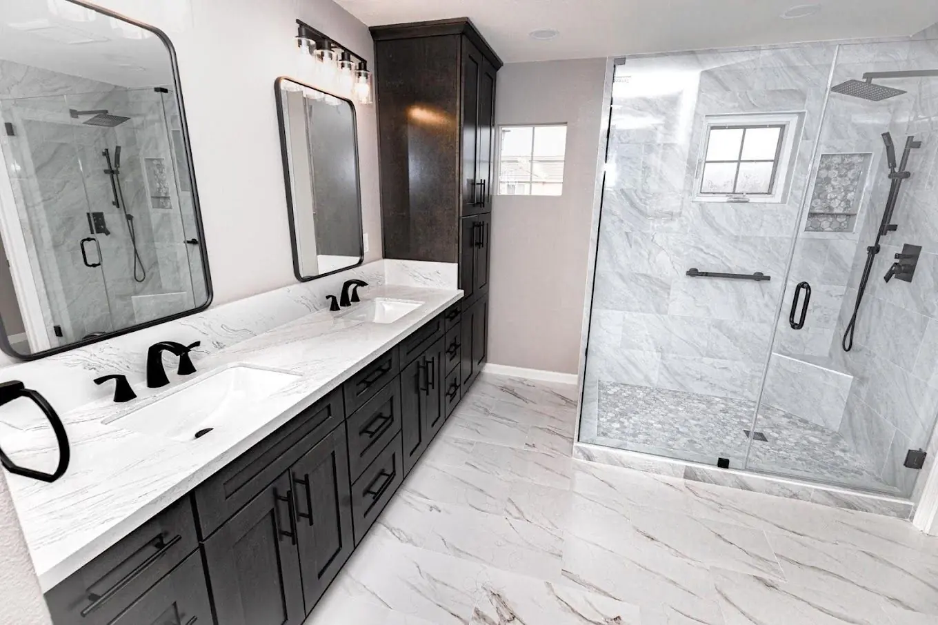 Master bath with marble walls, double vanity and glass shower