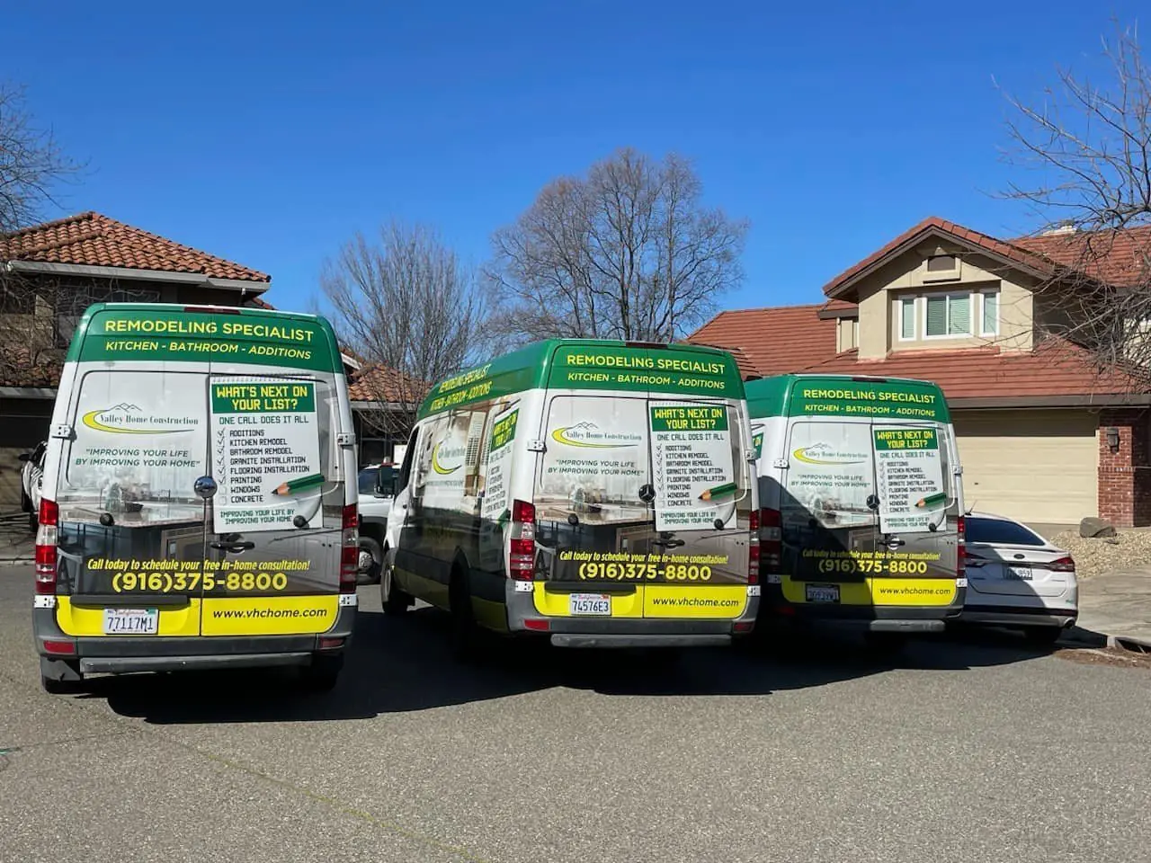 Three branded Valley Home Construction vans lined up in a driveway