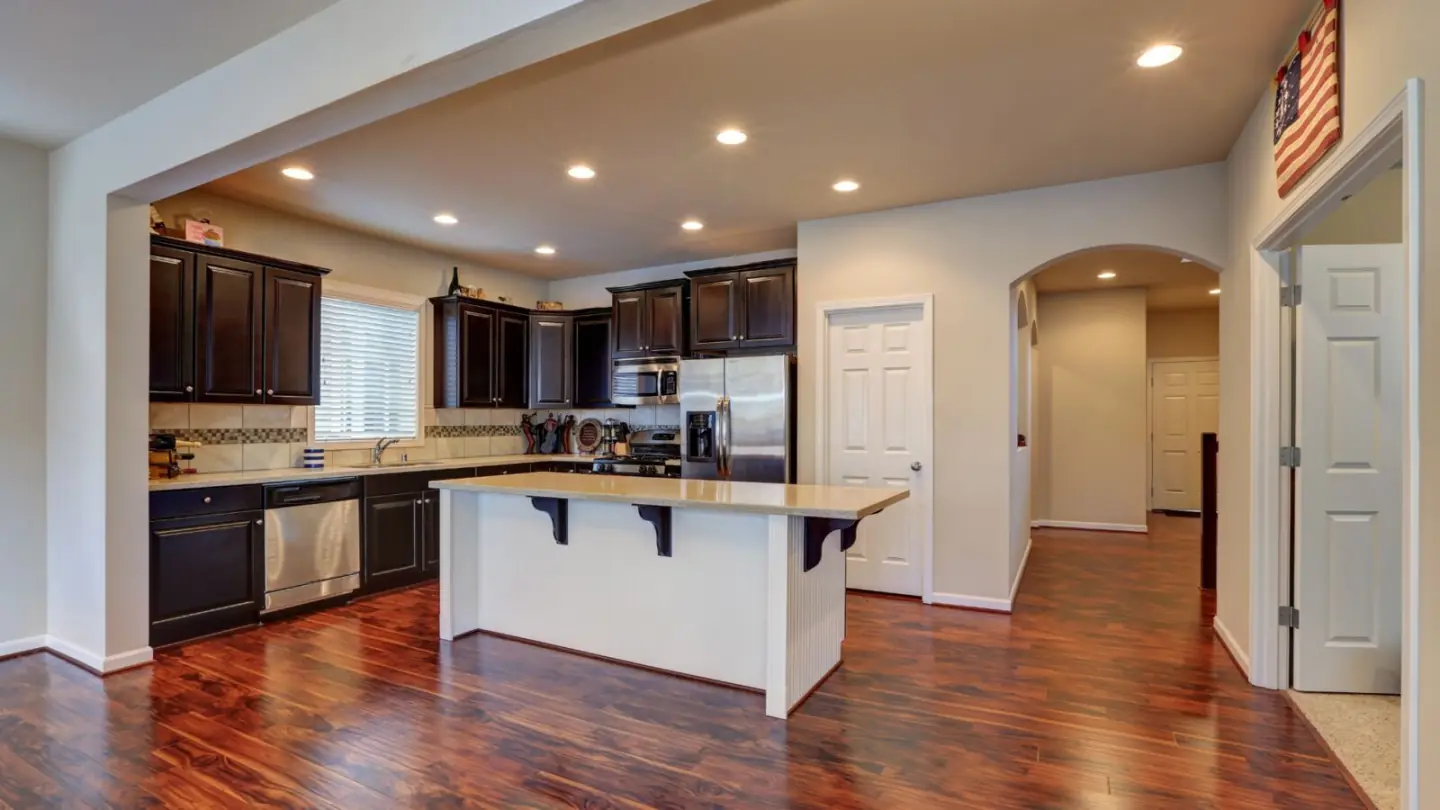 Remodeled kitchen with dark cabinets, island and hardwood floors by Valley Home Construction